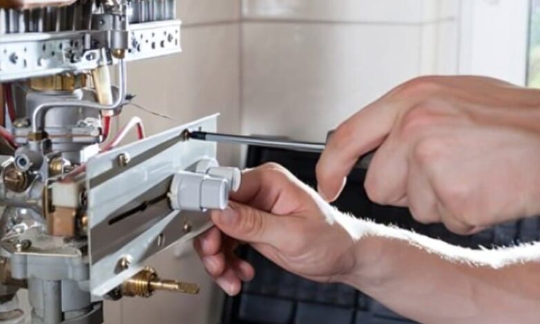 Why Your Hot Water System Matters at Home Types of hot water system shown during gas hot water unit repair by a plumber using tools on internal components