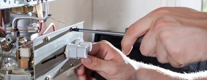 Why Your Hot Water System Matters at Home Types of hot water system shown during gas hot water unit repair by a plumber using tools on internal components