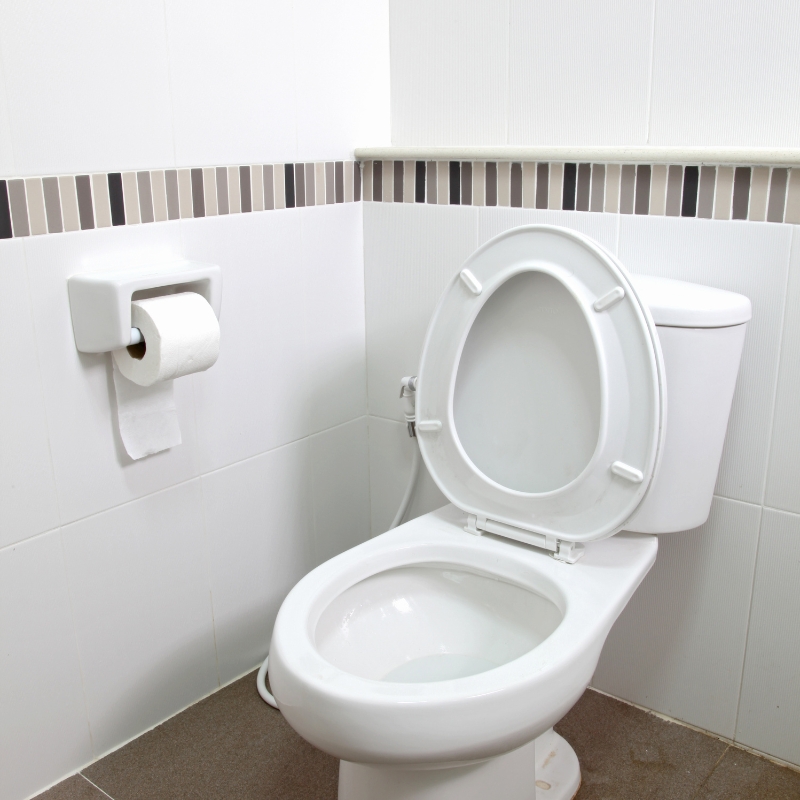 Clean white toilet with open lid in a tiled bathroom