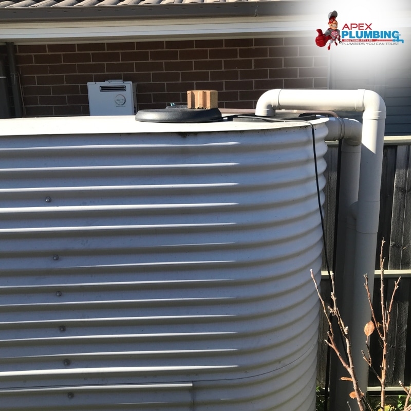 House water tanks system showing a large cylindrical tank with pipes connected, used for water storage in residential areas.