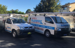 Two branded Apex Plumbing service vehicles parked in a driveway, clearly identifying a professional Plumber Sydney operation.