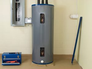 Water heater with an open access panel and tools nearby, potentially showing maintenance for low hot water pressure issues.