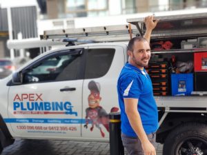 Professional plumber standing next to a van, ready to help when your sink won't drain or has issues.