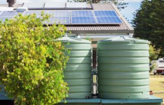 house water tanks green plastic tanks behind home with solar panels