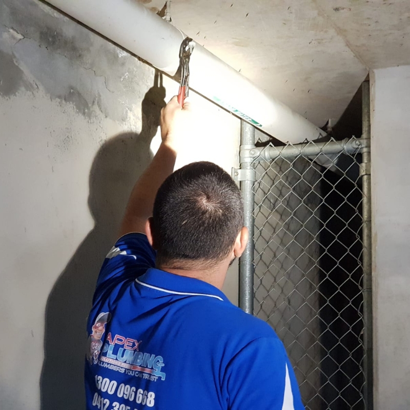 Burst pipe plumber replacing damaged pipe section using professional tools