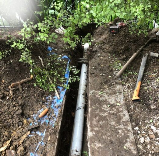 Excavated drain line exposed for diagnosis after repeated blockages before relining