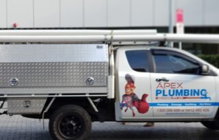 A branded Apex Plumbing service ute parked on a city street, clearly showing a professional Plumber Sydney vehicle with ladder rack.